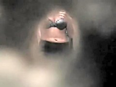 Girl in back bra seems to have noticed a hole in the wall