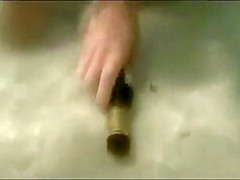My busty girlfriend sticks a beer bottle in her vagina and swims around