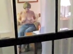 Naked mature woman masturbating through window