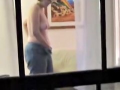 Naked mature woman masturbating through window