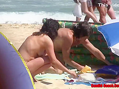 Naked woman is enjoying on the beach while people are staring at her trimmed pussy