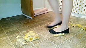 Suzi walks over unpeeled bananas, on floor, wearing her black ballet flats