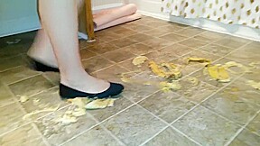 Suzi walks over unpeeled bananas, on floor, wearing her black ballet flats