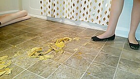 Suzi walks over unpeeled bananas, on floor, wearing her black ballet flats