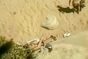 Un couple naturiste se touche et elle suce sur la plage