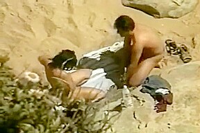 Un couple naturiste se touche et elle suce sur la plage